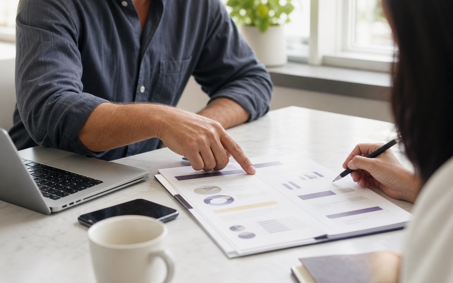 Consultant and business owner reviewing a marketing proposal before choosing an annual retainer or monthly fee